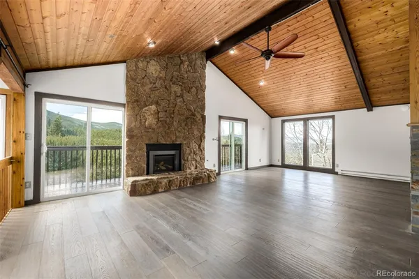 a view of a livingroom with wooden floor and a fireplace