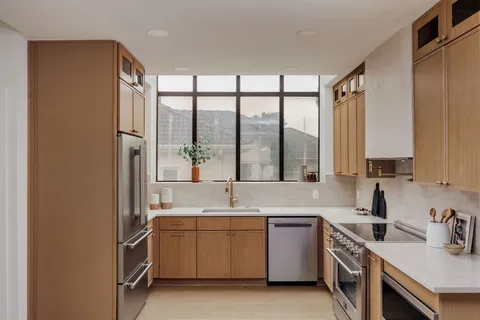 a kitchen with stainless steel appliances a stove sink and cabinets