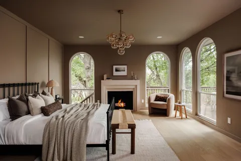 a spacious bedroom with a balcony a bed and a fireplace