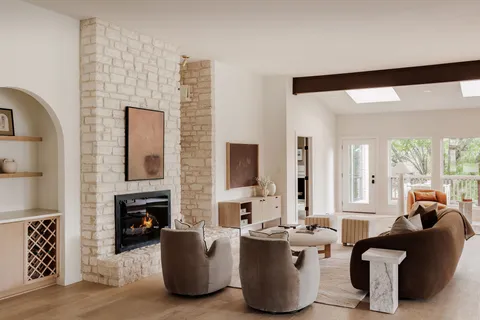 a living room with fireplace furniture and a large window