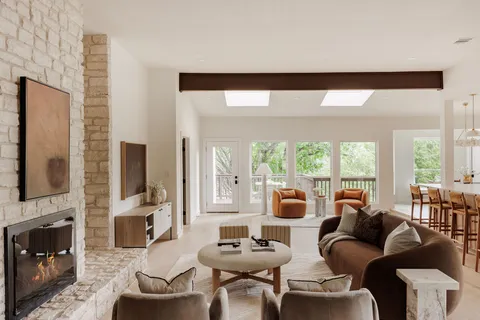 a living room with fireplace furniture and a large window