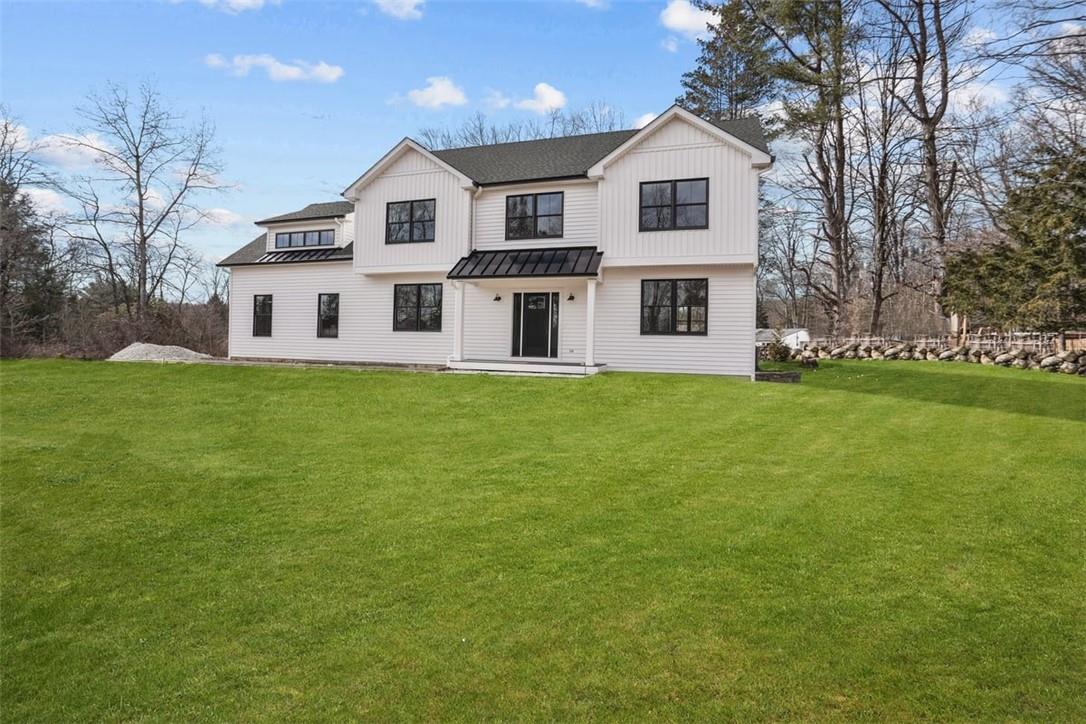 a front view of a house with a garden and trees