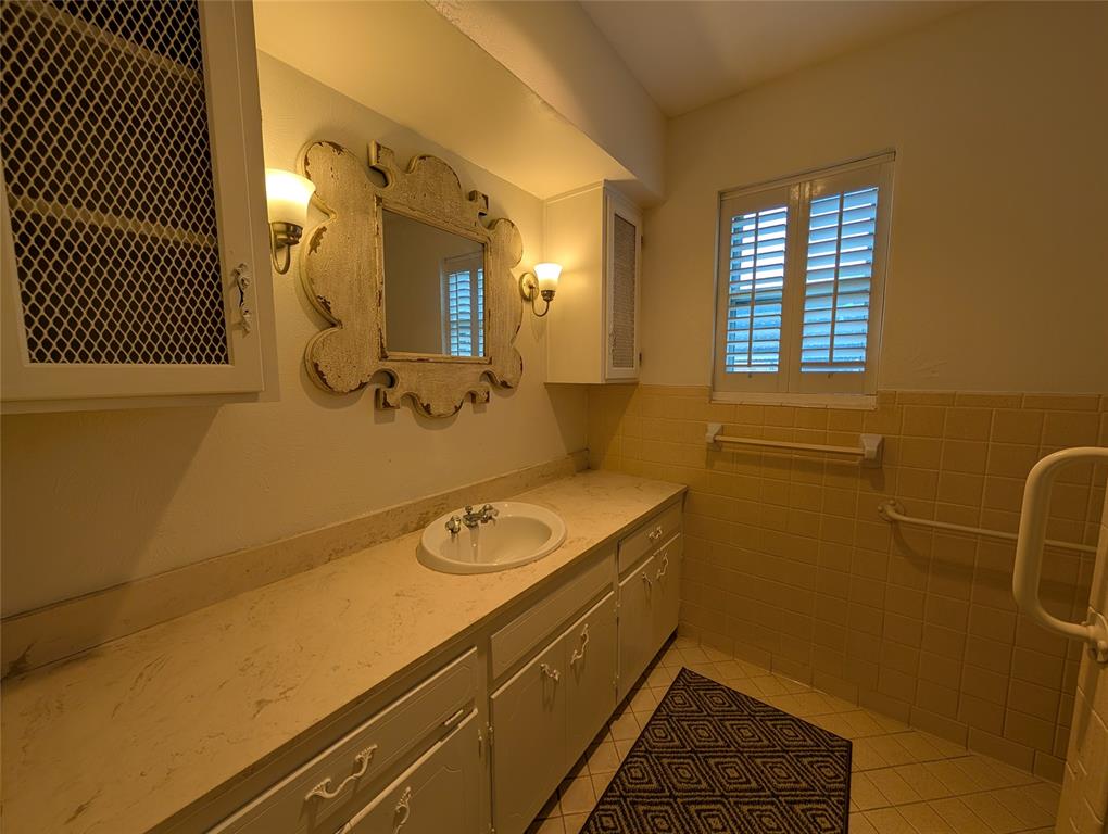 4715 Skillman Street, Unit A Dallas, TX 75206 - Photo 24 of 28 Bathroom featuring a spacious vanity with integrated sink, a framed mirror, and two wall sconces