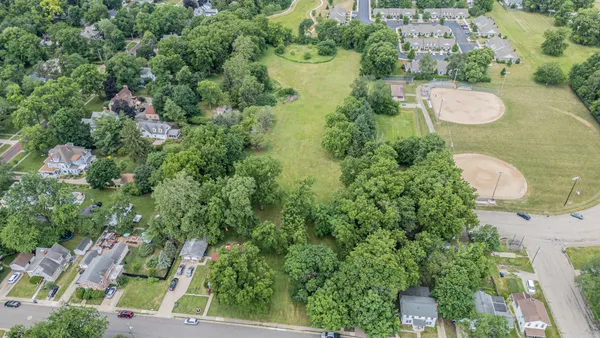 an aerial view of a residential houses with yard