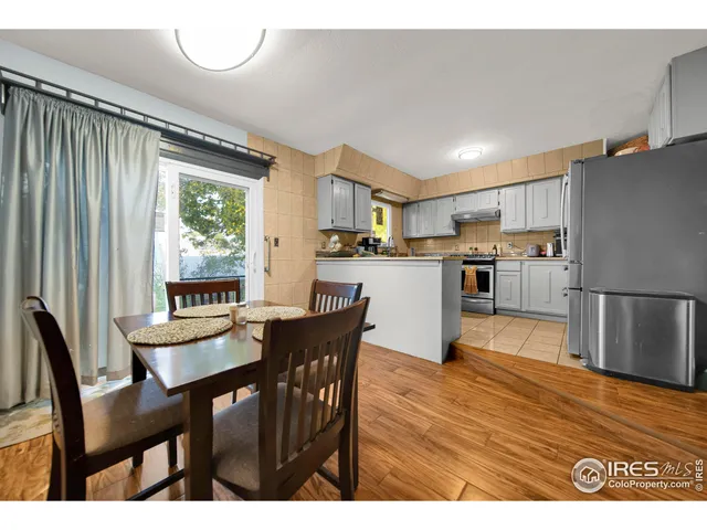 a kitchen with stainless steel appliances granite countertop a table chairs and a refrigerator