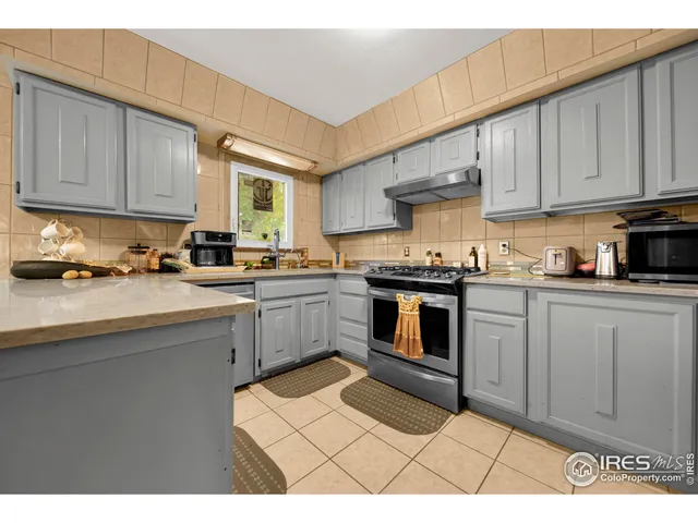 a kitchen with stainless steel appliances granite countertop a stove a sink dishwasher and a microwave oven with cabinets