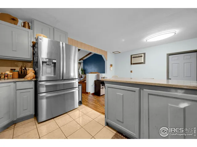 a kitchen with stainless steel appliances kitchen island granite countertop a refrigerator and a sink