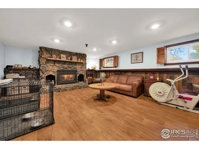 a living room with furniture a fireplace and gym equipment