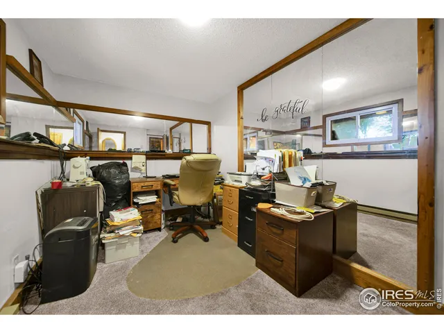 a view of a workspace with furniture and a window