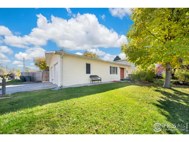 a view of a house with backyard and a tree