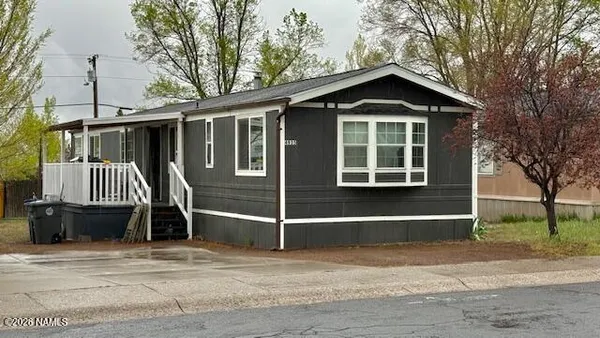 a view of a house with a yard and large trees
