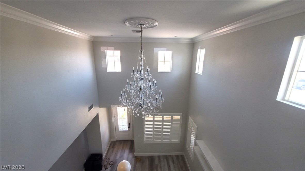 7903 Dell Ridge Avenue Las Vegas, NV 89179 - Photo 7 of 20 A grand chandelier illuminates this entryway with soaring ceilings and rich hardwood flooring.