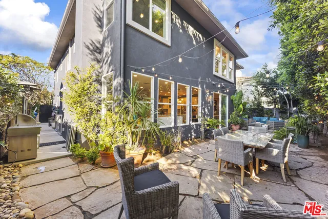 a view of a patio with couches table and chairs and potted plants