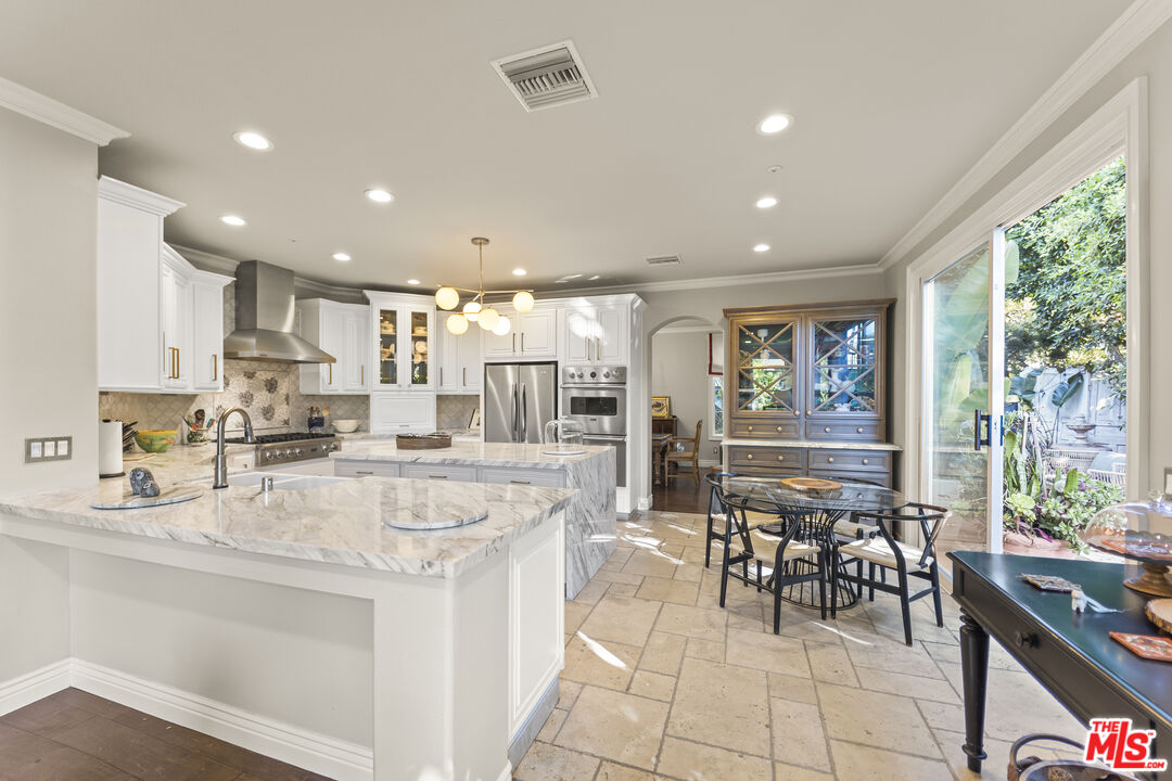 6738 Andover Lane Los Angeles, CA 90045 - Photo 8 of 24 a kitchen with stainless steel appliances kitchen island granite countertop a stove a refrigerator a sink and white cabinets with wooden floor
