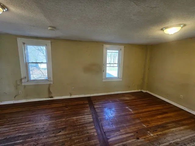 a view of wooden floor and windows in a room