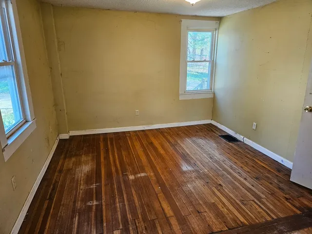 a view of a room with wooden floor and window