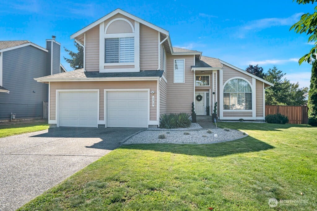 a front view of a house with a yard and garage