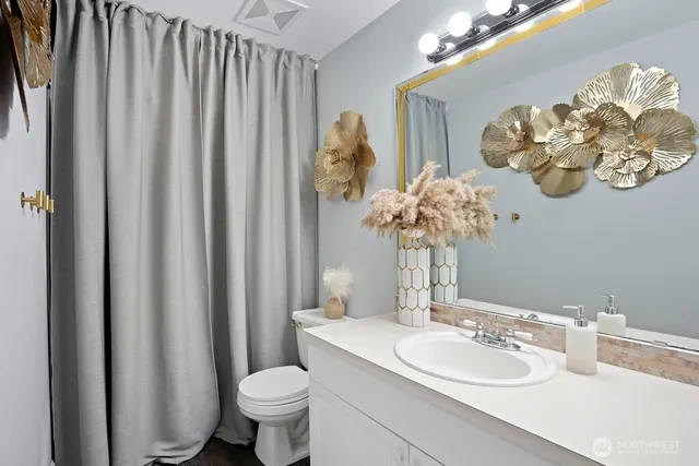a bathroom with a toilet a sink and a mirror