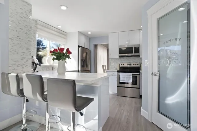 a kitchen with stainless steel appliances granite countertop a refrigerator and a stove top oven