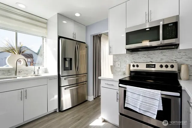 a kitchen with stainless steel appliances a stove microwave and a refrigerator