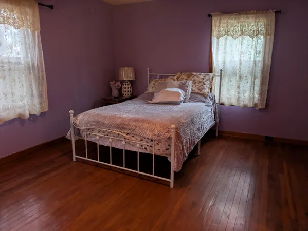 a bed sitting in a bedroom next to a window