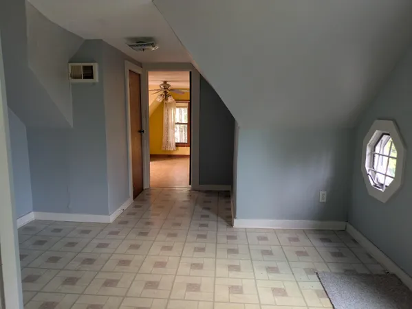 a view of a hallway to a room with a window