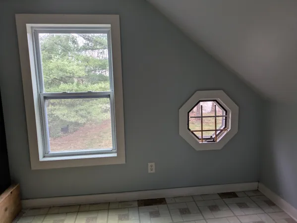 an empty space with wooden floor and windows