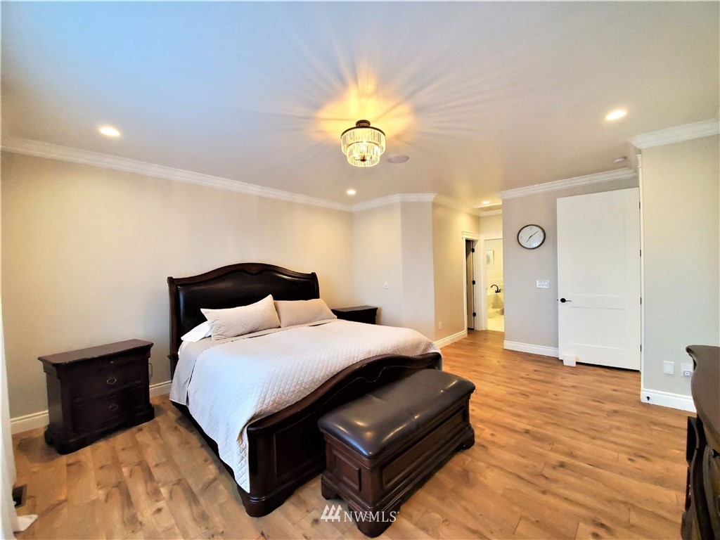 6737 Rd D.8 Northeast Moses Lake, WA 98837 - Photo 15 of 24 a spacious bedroom with a bed and a chandelier