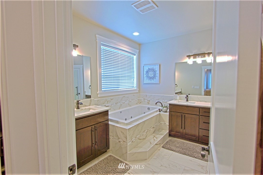 6737 Rd D.8 Northeast Moses Lake, WA 98837 - Photo 16 of 24 a spacious bathroom with a granite countertop sink a mirror a bathtub and window