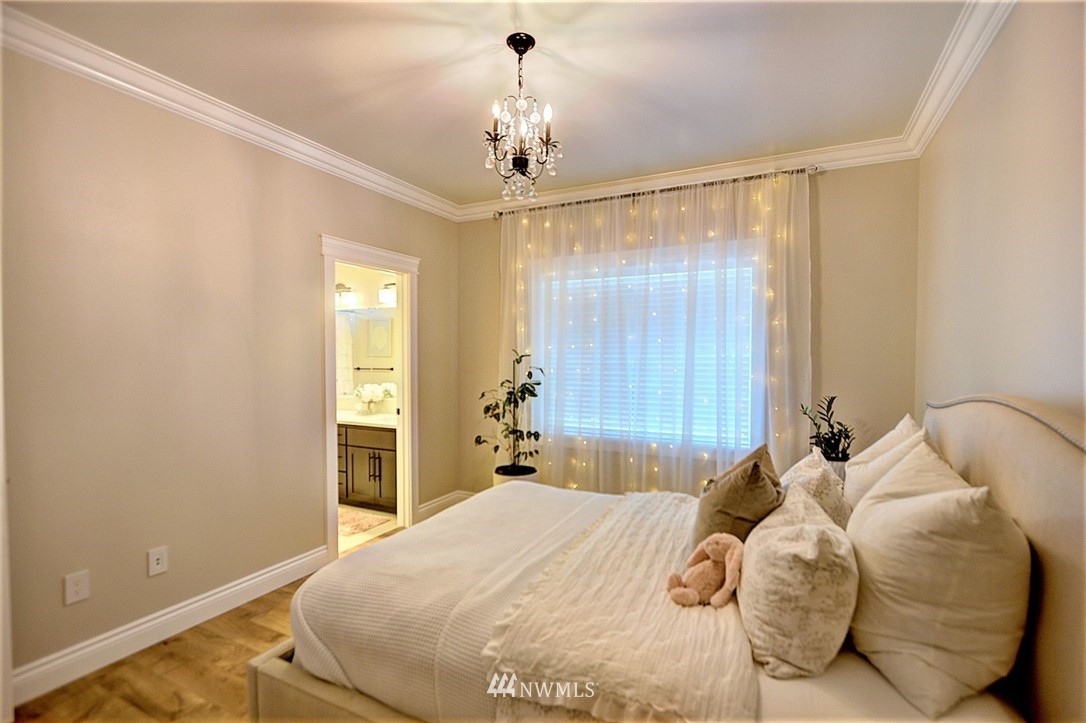 6737 Rd D.8 Northeast Moses Lake, WA 98837 - Photo 18 of 24 a bedroom with a bed and a chandelier