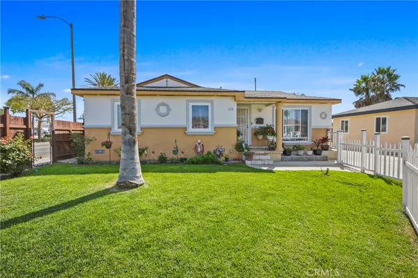 a view of a house with backyard and a tree