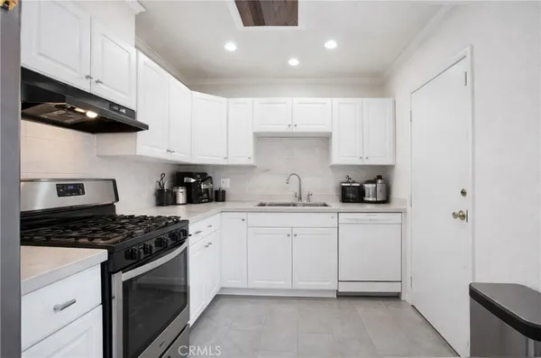 a kitchen with cabinets stainless steel appliances and a counter space