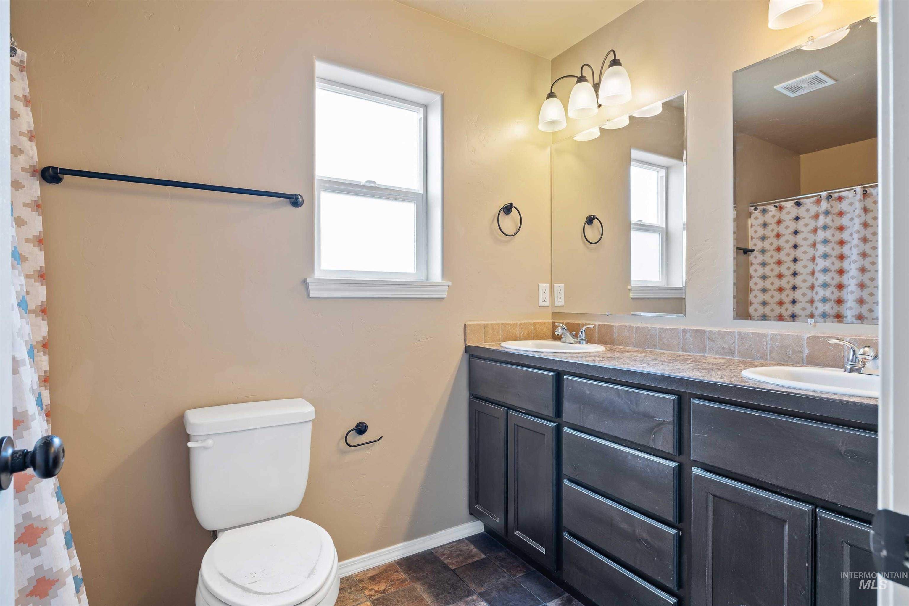 134 North 50 West Rupert, ID 83350 - Photo 12 of 36 Full bath with plenty of natural light, double vanity, and stone finish flooring