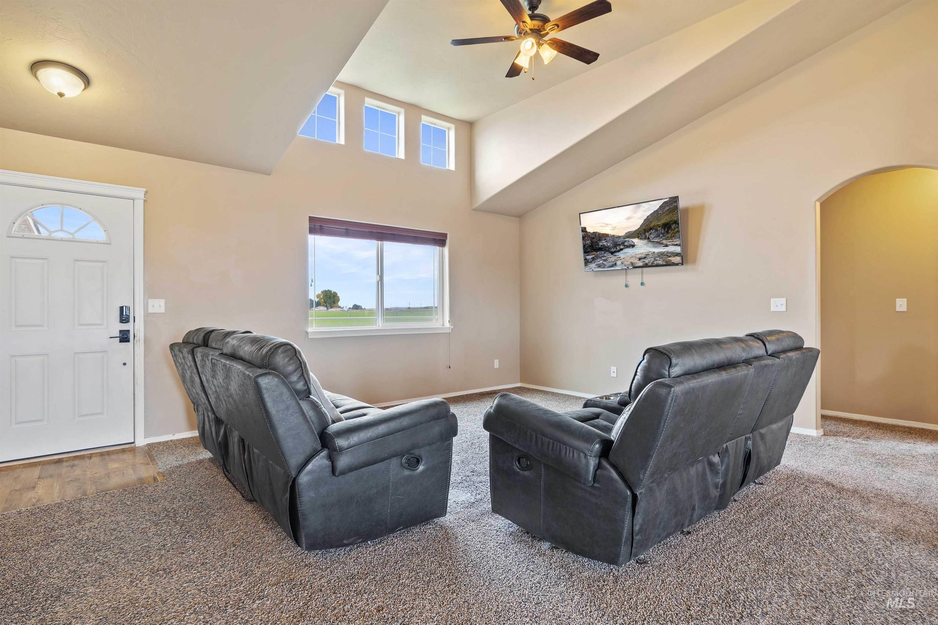 134 North 50 West Rupert, ID 83350 - Photo 5 of 36 Living room with arched walkways, high vaulted ceiling, carpet flooring, and ceiling fan