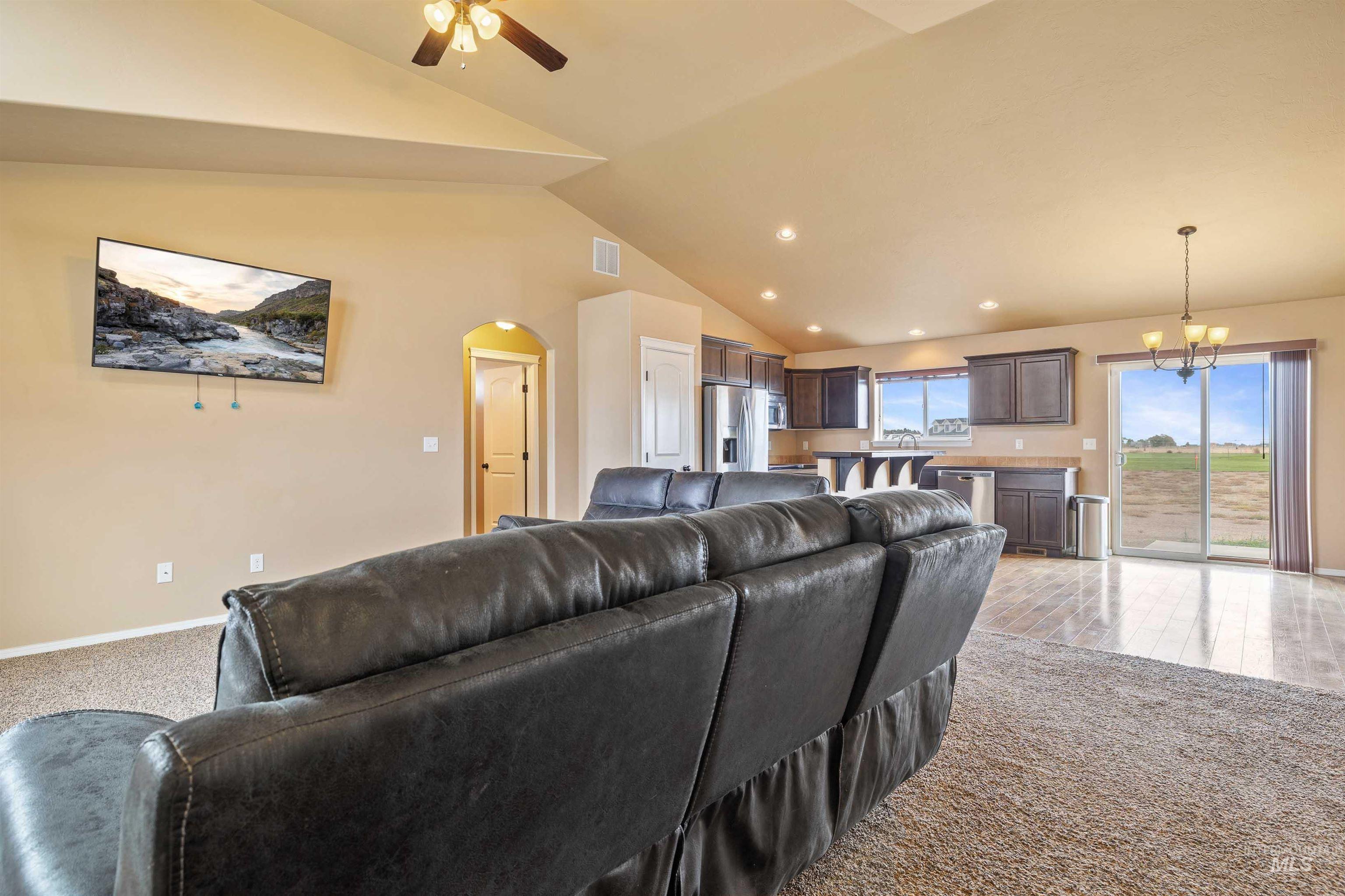 134 North 50 West Rupert, ID 83350 - Photo 6 of 36 Living area featuring light colored carpet, arched walkways, ceiling fan, a chandelier, and recessed lighting