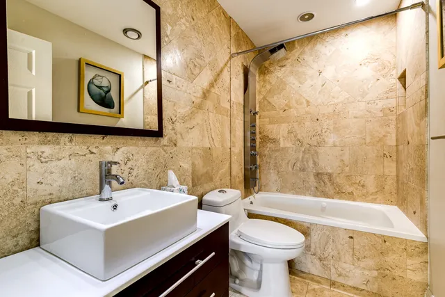 a bathroom with a sink a toilet and shower