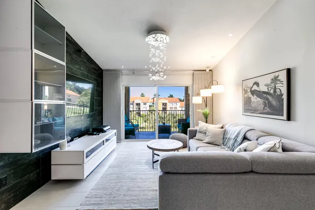 a living room with furniture a chandelier and a large window