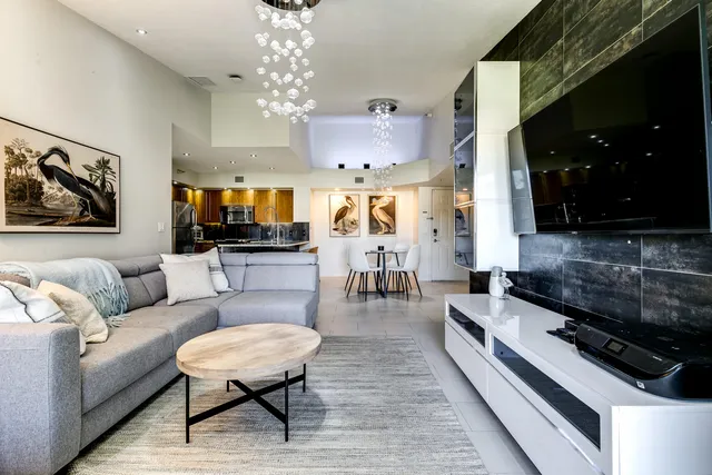 a living room with furniture and a chandelier