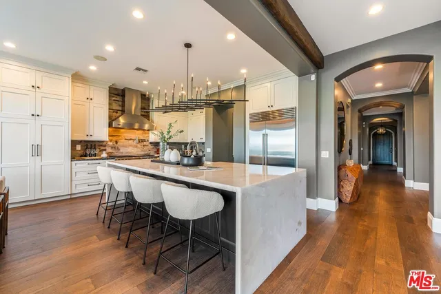 a large white kitchen with a large window and furniture