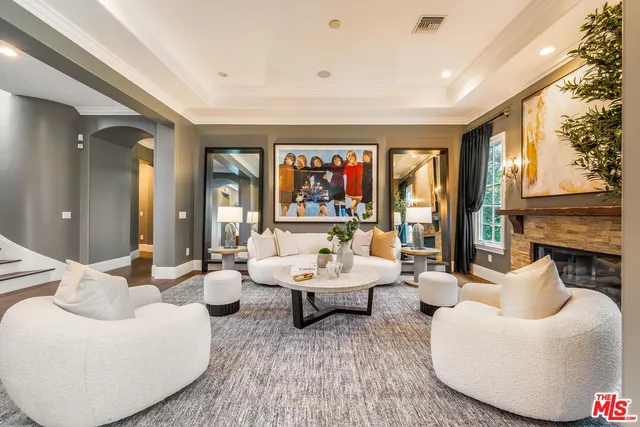 a living room with furniture a fireplace and a large window