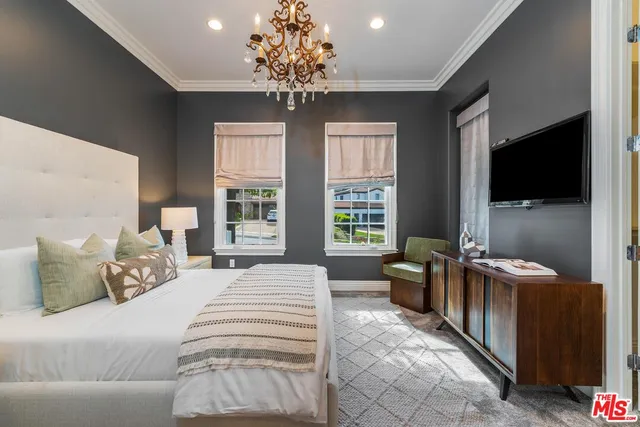 a bedroom with a large bed and a large mirror