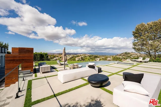 a view of a house with a yard and potted plants