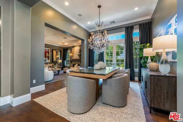 a living room with furniture a chandelier and a dining table