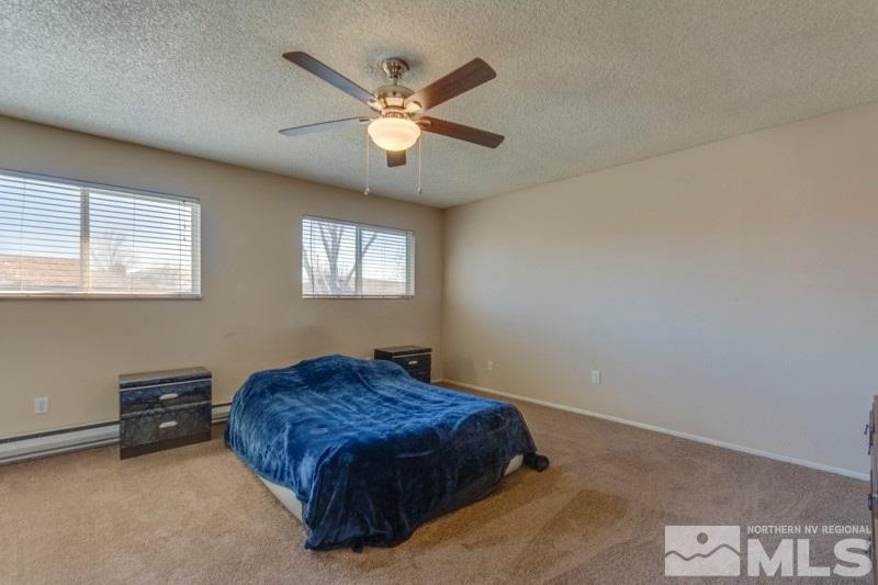 404 Smithridge Drive Reno, NV 89502 - Photo 7 of 12 a bedroom with a large bed and a chandelier