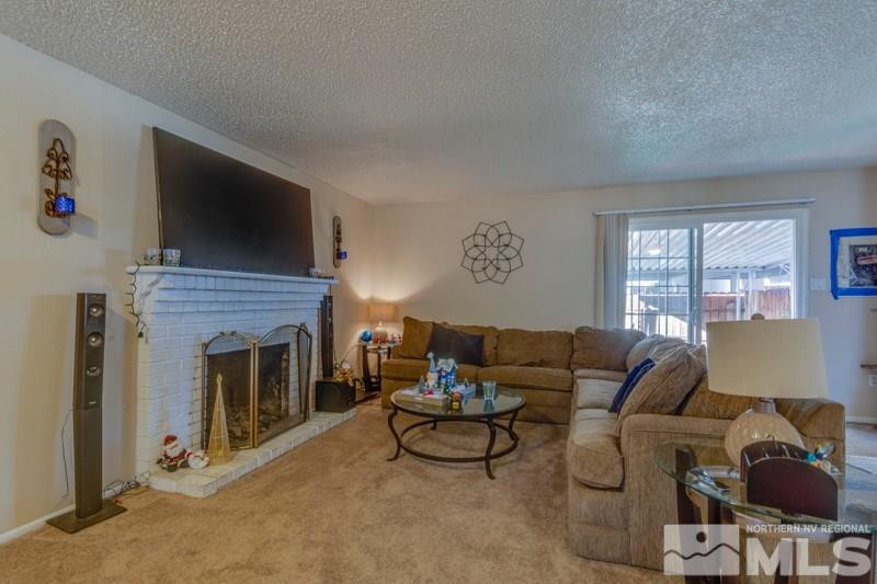404 Smithridge Drive Reno, NV 89502 - Photo 8 of 12 a living room with furniture a fireplace and a flat screen tv