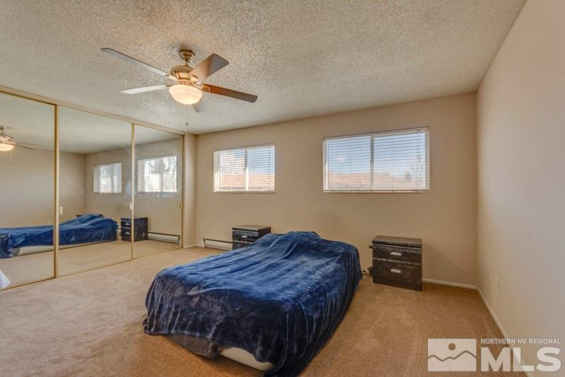 404 Smithridge Drive Reno, NV 89502 - Photo 9 of 12 a spacious bedroom with a bed and a chandelier