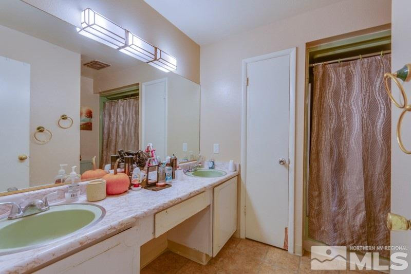 404 Smithridge Drive Reno, NV 89502 - Photo 10 of 12 a bathroom with double vanity sinks a mirror and a shower