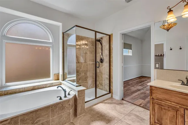 a spacious bathroom with a tub shower and a sink