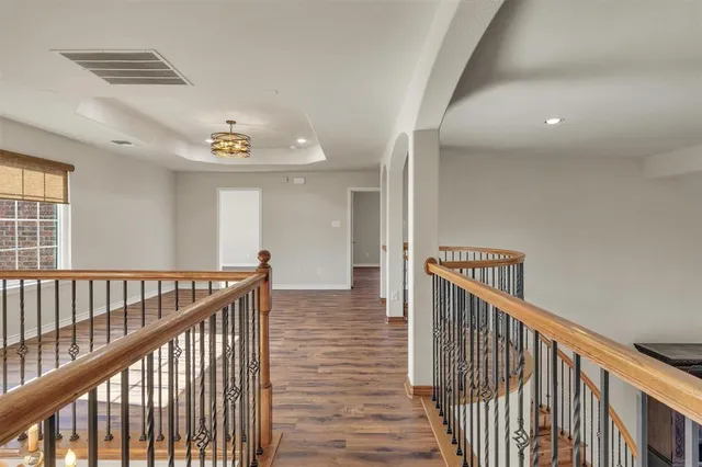 a view of a hallway with wooden floor and windows