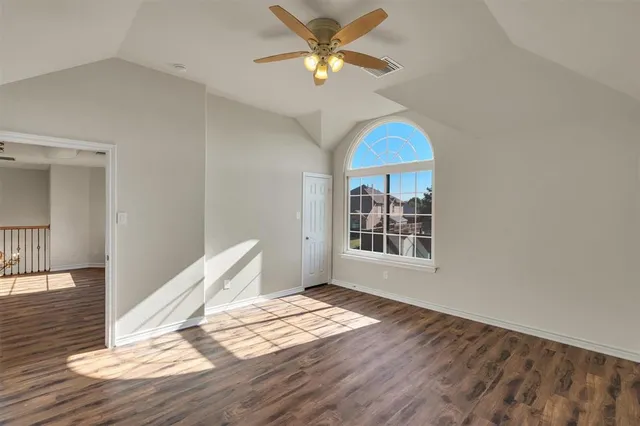 a view of a room with wooden floor and a ceiling fan